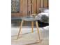 Une table basse grise avec des pieds en bois dans un intérieur moderne.