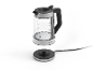 Glazen waterkoker met oplaadstation, toont volumemetingen.