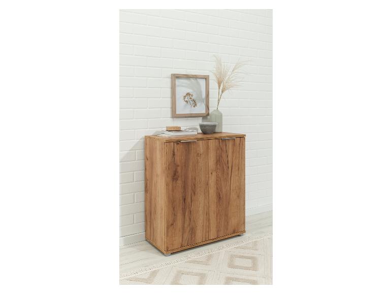 Een houten kast met twee deuren voor in de woonkamer.