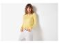 Femme en pull jaune à manches longues et pantalon blanc avec ceinture