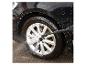 Lavage d'une roue de voiture au nettoyeur haute pression, avec de la mousse sur la carrosserie.