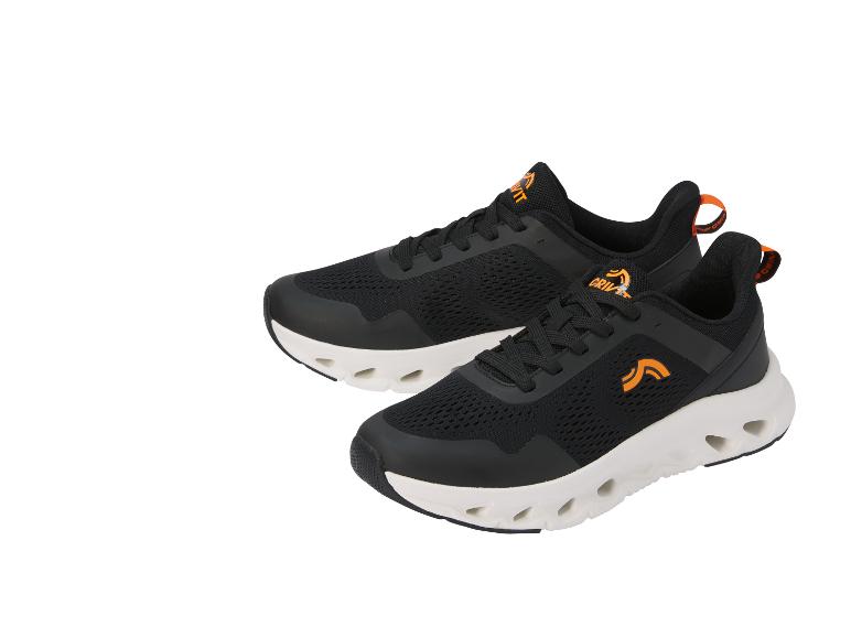 Chaussures de sport noires avec détails orange et semelle blanche perforée.
