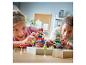 Deux enfants jouent avec des voitures de course jouets et des accessoires de piste sur une table en bois.