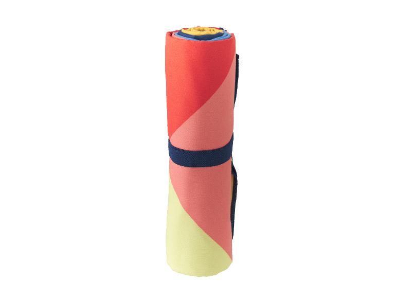 Opgerolde strandhanddoek met geometrische patronen in rood-, roze- en geeltinten, met een marineblauwe band.