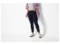 Donkerblauwe jeans, gestreept overhemd en witte sneakers.