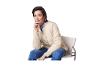 Une femme assise sur une chaise portant une veste beige et un jean.