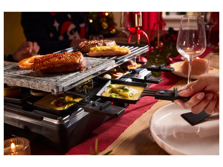 Raclette met gegrild vlees en zeevruchten, gesmolten kaas en groenten.