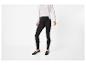 Femme en leggings noirs, haut côtelé blanc et cardigan blanc à boutons de perles.