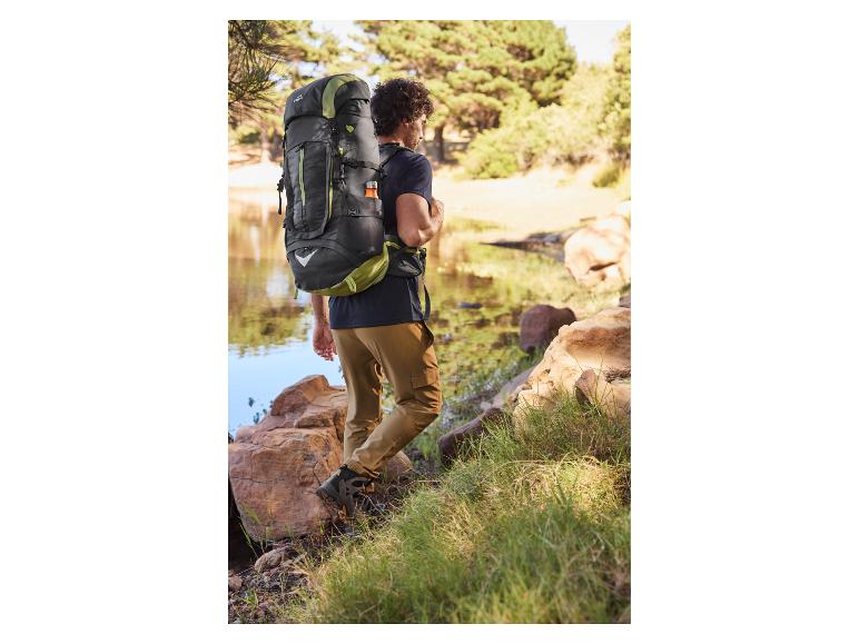 Sac à dos de randonnée et chaussures de marche près d'un lac.