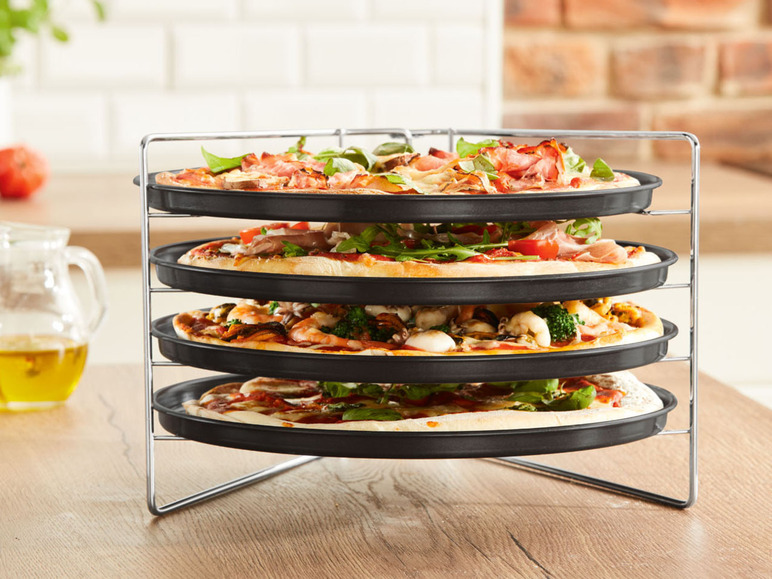 Quatre pizzas sur un support métallique.