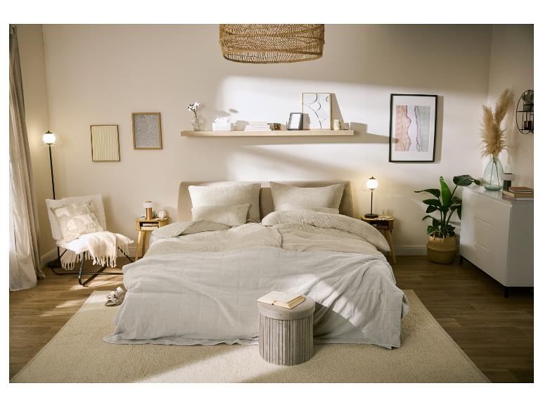Chambre confortable aux tons neutres avec lit, tables de chevet, lampe et décorations.