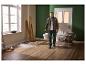 Homme en tenue de travail avec un seau dans une pièce en rénovation.