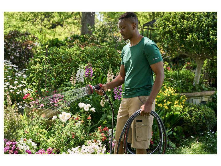 Man besproeit tuin met Parkside slang en sproeier.