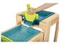 Een houten speeltafel met twee blauwe waterbakken en een groene watergieter.