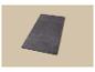 Un tapis rectangulaire gris foncé moelleux sur un fond beige clair.