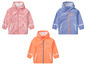 Drie regenjassen met regenboogmotief.