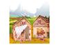 Tente de jeu en forme de ferme avec un bébé et des animaux, sur fond de montagnes.