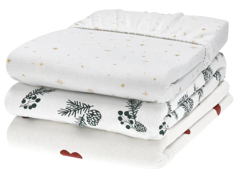 Drie sets babybeddengoed met sterren-, dennenappel- en hartpatronen.