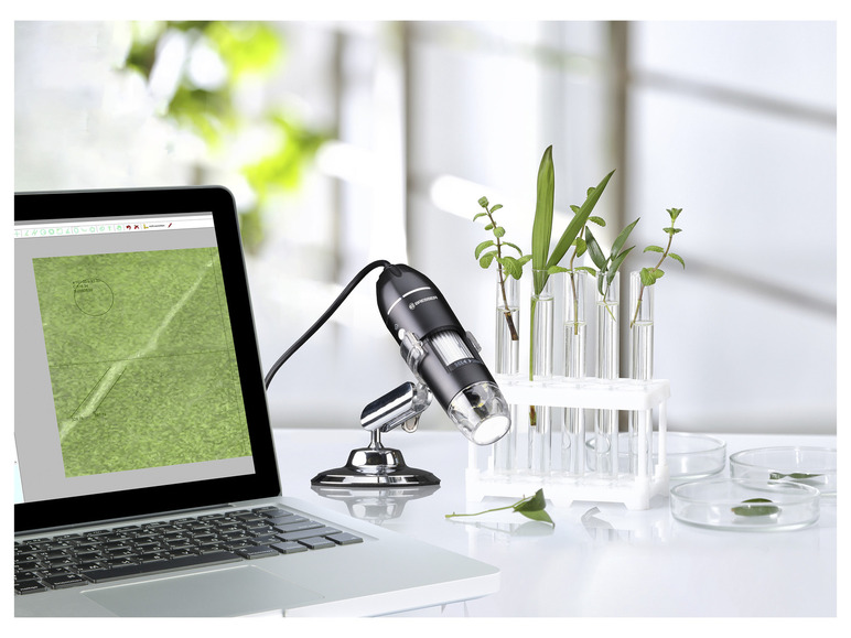 Un microscope Bresser, un ordinateur portable et des tubes à essai avec des plantes.