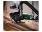 Personne utilisant une brosseuse à bois avec tuyau d'extraction de poussière sur une surface en bois.