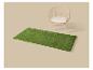 Tapis d'herbe artificielle verte avec une chaise en osier et coussin.