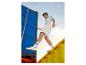 Mannelijk model in short, overhemd met print en Deluxe sneakers.