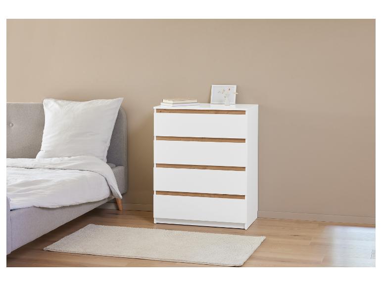 Een wit dressoir met vier lades in een slaapkamer.