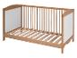 Un lit bébé en bois avec des barreaux et un sommier à lattes.