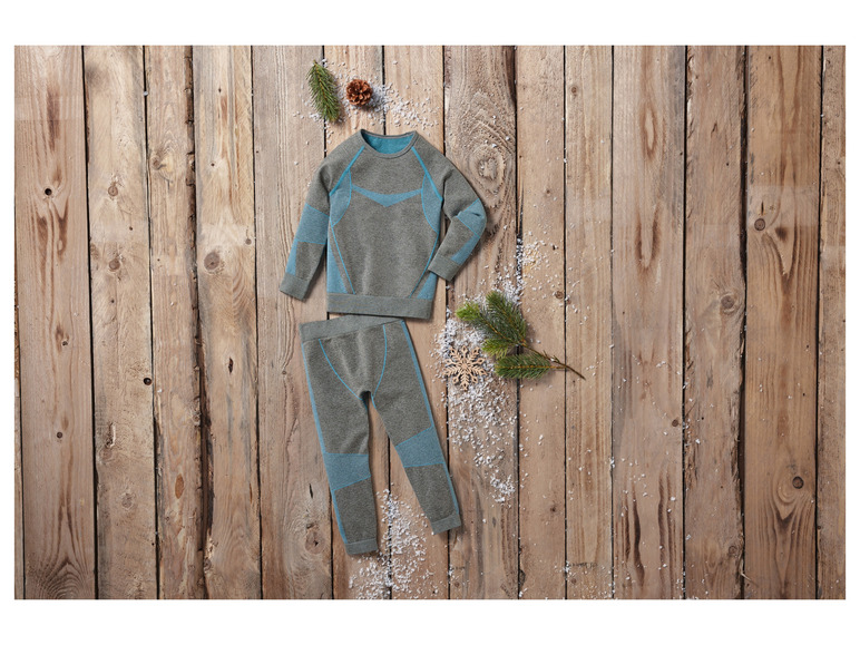 Un ensemble de sous-vêtements thermiques gris avec des détails bleus sur un fond en bois.