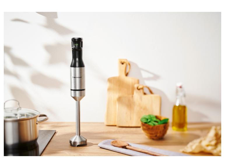 Un mixeur plongeant SilverCrest sur un comptoir de cuisine avec une casserole et des ustensiles.