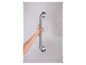 Een hand houdt een zilverkleurig metalen handvat vast dat aan een muur is bevestigd.