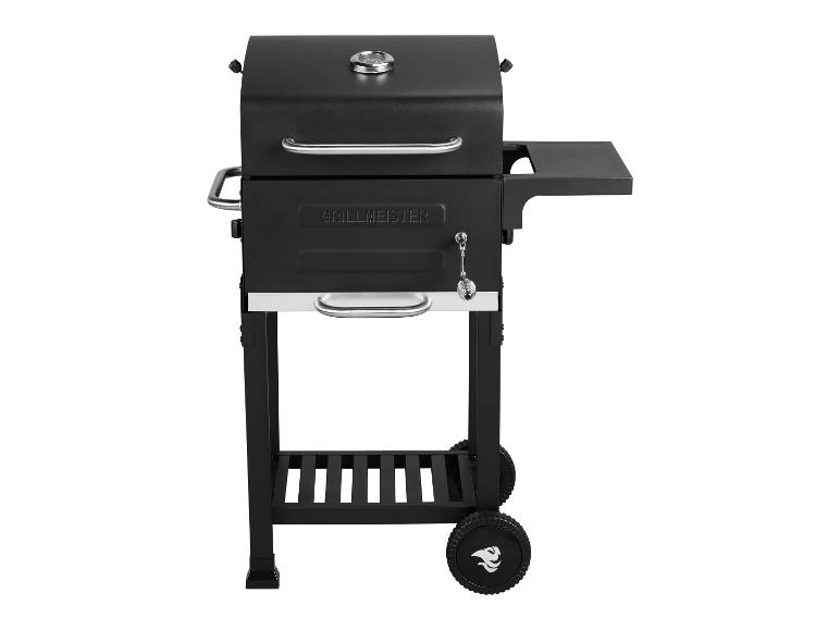 Barbecue noir Grillmeister avec deux grilles et des roues.