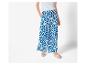 Pantalon large à imprimé bleu et blanc et sandales plates.
