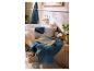 Badkamer met blauwe en beige handdoeken, een witte wastafel en groene planten.