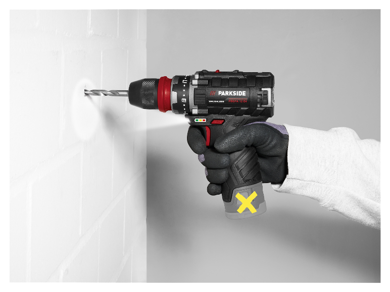 Een werknemer gebruikt een Parkside accu-boormachine om een gat in een muur te boren.