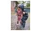 Twee kinderen spelen in plassen met hun regenkleding en laarzen.