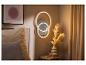 Wandlamp met lichtgevende ringen, bed, nachtkastje en decoratie in een slaapkamer