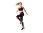Femme en brassière de sport noire et leggings à motifs faisant de l'exercice.