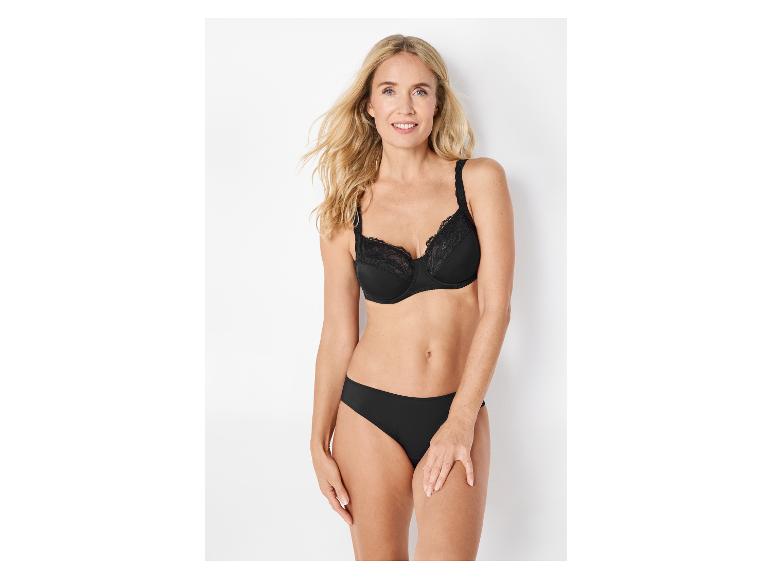 Lachende vrouw in zwarte kanten beha en slip.