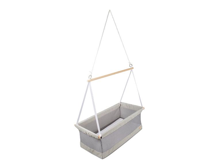 Hangende babywieg met een lichtgrijze stoffen mand en houten stang.