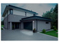 Une maison moderne avec un portail de garage et une lumière extérieure