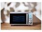 Zilveren magnetron met digitaal display op een houten aanrecht.