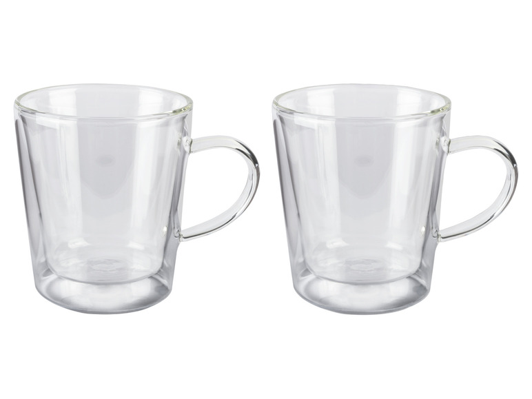 Twee lege glazen bekers met handvatten