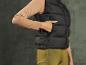 Gilet matelassé noir à manches longues et pantalon vert.