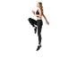 Vrouw in zwarte sportbeha en Jette Sport legging in hardloophouding.