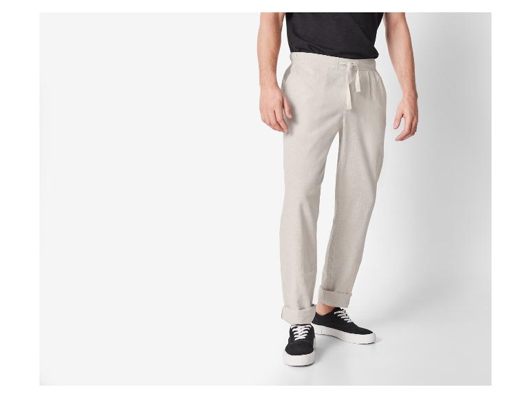 Beige linnen broek en zwarte sneakers: casual look.