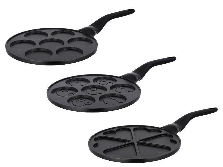 Drie zwarte pannenkoekenpannen met verschillende vormen: rond, smiley en hart.