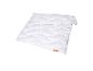 Couette blanche matelassée avec motif ondulé et petite étiquette marron