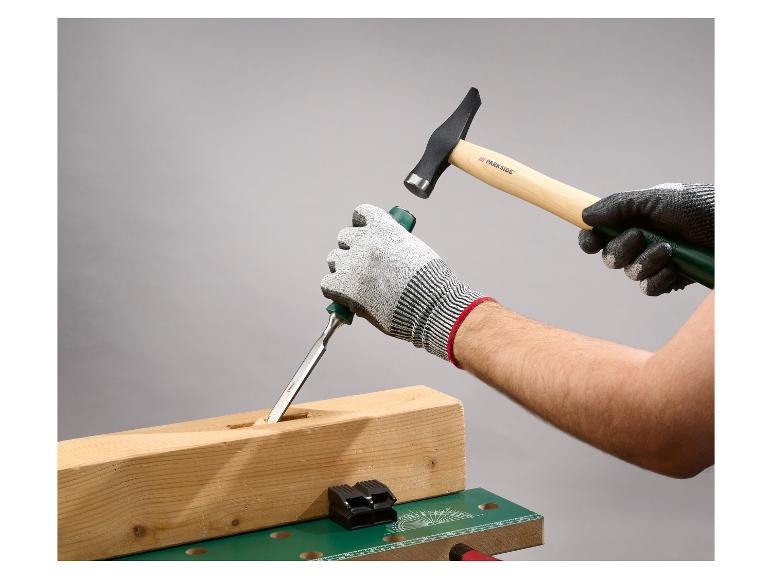 Gehandschoende handen gebruiken een beitel en hamer om een houten balk te bewerken.