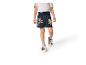 Kind draagt donkerblauwe shorts met stripfiguren en sneakers.
